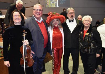 A group of people posing for a picture with a violin.